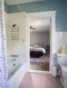 - une salle de bains avec baignoire et un lit dans une chambre dans l'établissement The Manor at Glen Jean Meadows, 
