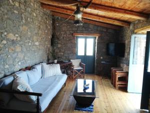 - un salon avec un canapé bleu et un mur en pierre dans l'établissement Pappou's Traditional Cottage at Epano Elounda, à Elounda