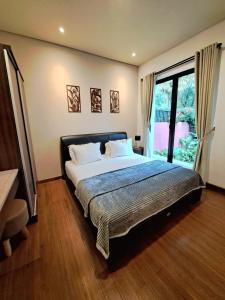 a bedroom with a bed and a large window at THE OASIS 4BR Private Pool Pet-Friendly Villa Vimala Hills in Gadok 1