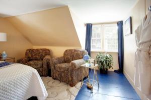 a bedroom with two chairs and a bed at Inn On Main in Yarmouth Port