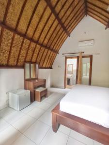 a bedroom with a bed and a wooden ceiling at Follow The Rabbit Bungalow in Gili Islands