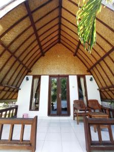 a room with a wooden ceiling and two benches at Follow The Rabbit Bungalow in Gili Air