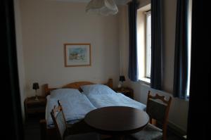 a bedroom with a bed and a table and a window at Hotel Kappelner Hof in Kappeln