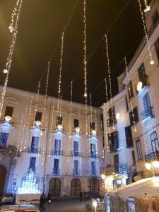 un gran edificio blanco con luces de Navidad colgando de él en PETRAMARE Charming House, en Salerno
