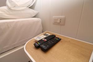 two remote controls sitting on a table next to a bed at Hercules Room in Himare