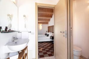 a bathroom with a sink and a toilet at REEF Suites in Olbia