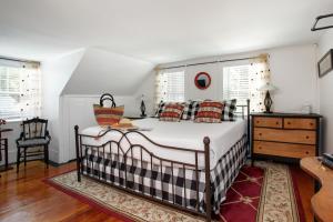 een slaapkamer met een bed, een dressoir en ramen bij Inn On Main in Yarmouth Port