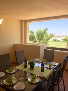 comedor con mesa y sillas y ventana grande en Casa Moriarty en Murcia
