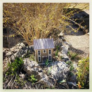 格雷奧利艾的住宿－Petit chalet pour amoureux de la nature au « Domaine de Tara »，一座小房子,坐在一些岩石上