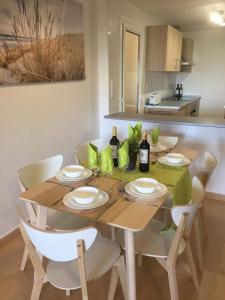 una mesa de comedor con sillas y botellas de vino. en Casa Moriarty, en Murcia