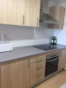 a kitchen with wooden cabinets and a black stove top oven at Casa Moriarty in Murcia