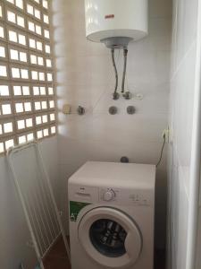 a small bathroom with a washing machine and a light at Casa Moriarty in Murcia