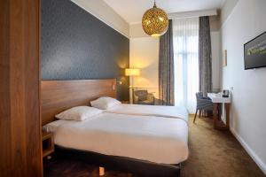 a hotel room with a large bed and a window at Parkhotel Valkenburg in Valkenburg