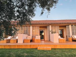 una terraza de madera con sillas y una casa en Vinha by NHôme en Ponte de Lima