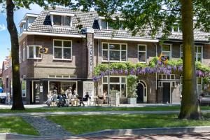 people sitting at tables outside of a building at Bed & Breakfast - Gallery 't Speelhuys in Breda