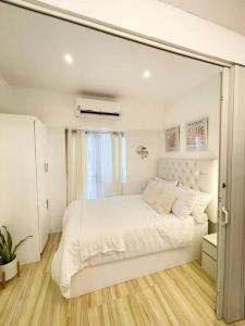 a white bedroom with a large white bed in it at Victoria Sports Tower - Cozy Ambiance Condo Unit in Manila