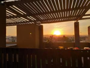 a view of the sunset from a deck with a pergola at Amaris Hotel in Ica