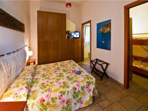 a bedroom with a bed with a floral bedspread at Villaggio Camping Spiaggia Del Riso in Villasimius