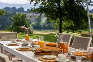 einen Tisch mit einem Frühstück mit Brot und Orangensaft in der Unterkunft Villa Colonica Tuori at Tenuta Schifanoia in San Piero a Sieve