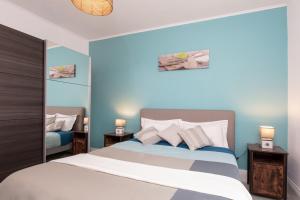 une chambre avec un grand lit avec deux tables de nuit dans l'établissement Le Green St Léon : Lit Queen Size * WIFI * Idéal Couple, à Colmar