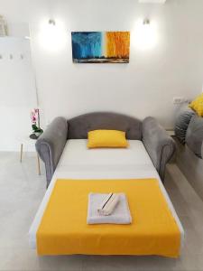 sala de estar con sofá y manta amarilla en Apartment Marina en Kotor