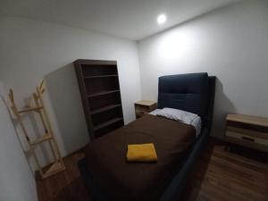 a bedroom with a bed with a yellow pillow on it at Nejapa Irrigación Embajada Americana in Mexico City