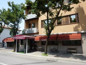 a building with tables and chairs in front of a building at Alla Bianca Hotel in Marghera