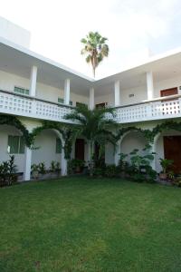 Vista anterior de un edificio con patio verde en NAH SAM CHAK La Casa Rosada, en Tapachula