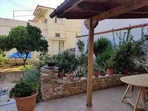 a patio with potted plants and a stone wall at Cozy apartment in Peania (near Airport) in Paianía