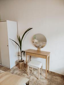 a dressing table with a mirror and a plant at Cozy apartment in Peania (near Airport) in Paianía