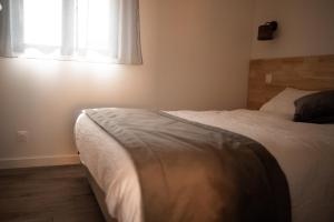 a bedroom with a white bed with a window at Les Cottages de Ripaille in Thonon-les-Bains