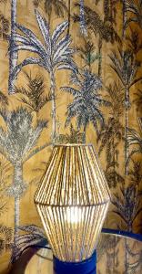 a gold lamp sitting on a table in front of a wall at Les Remparts Antibes Location in Antibes