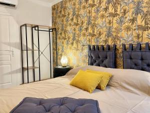 a bedroom with a large bed with a yellow pillow at Les Remparts Antibes Location in Antibes