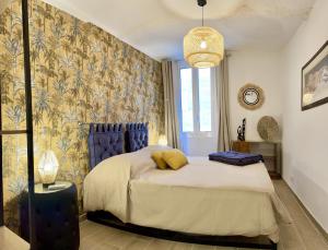 a bedroom with a bed with a blue head board at Les Remparts Antibes Location in Antibes