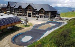 a resort with a swimming pool in front of a building at Le Cosy Pyrénées pied de pistes Sérias in Germ