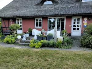 una casa roja con techo de paja en Ferienatelier 2, en Steffenshagen