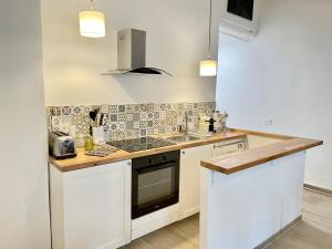 a kitchen with a sink and a stove top oven at Les Remparts Antibes Location in Antibes