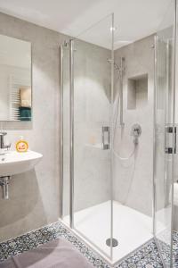 a shower with a glass door in a bathroom at Ferienappartements Im alten Fährhaus in Niederhausen