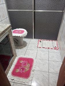 a bathroom with a shower with a toilet and two mats at CASA DA LÉIA in Caparaó Velho