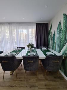a dining room with a table with chairs and plants on the wall at Luxury 2 bedroom holiday apartment in Braşov