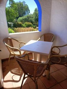 a table and chairs in a room with a window at El Palomar Rooms Tarifa in Tarifa