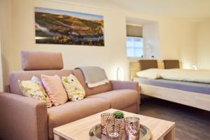 a living room with a couch and a bed at Ferienappartements Hermannshöhle in Niederhausen
