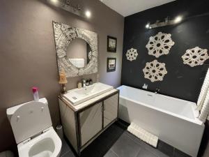 uma casa de banho com um lavatório, uma banheira e um WC. em @Grace Guesthouse em Klerksdorp
