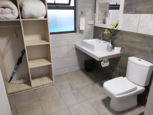 La salle de bains est pourvue de toilettes blanches et d'un lavabo. dans l'établissement Entre Mer et Montagne, à Rodrigues Island