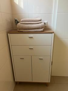 a white dresser with towels on it in a bathroom at Ferienwohnung Lis in Bermatingen