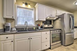 uma cozinha com armários brancos e um frigorífico de aço inoxidável em Cozy Pittsboro Escape - Hike, Dine, Explore! em Pittsboro