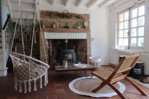 sala de estar con 2 sillas y chimenea en Gite des Trévignes, en Cambremer