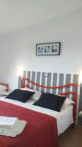a bedroom with a large bed with a red and white headboard at Residence San Antonio in Marina di Camerota