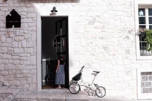 a woman is standing in a doorway with a bike at HomeSanGil in Burgos