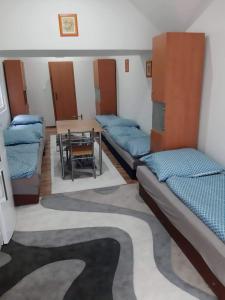 a room with a row of beds and a table at Ubytovanie v súkromí in Dolné Plachtince